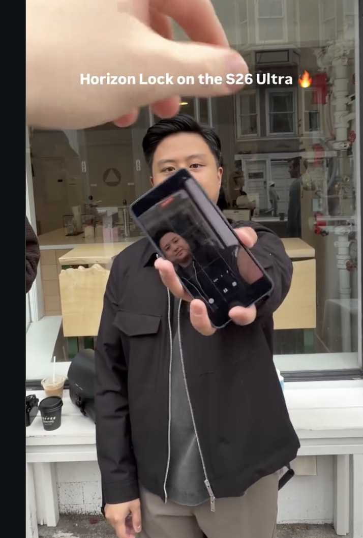 Still from the Instagram video linked in the previous post. It shows a meta recording (a recording of a phone that is also recording) where the phone being recorded is passed from one person to another to do a full rotation of the phone while recording a single shot. On the phone screen, you can see the subject's head is fully to the left of the recording frame after the handoff.